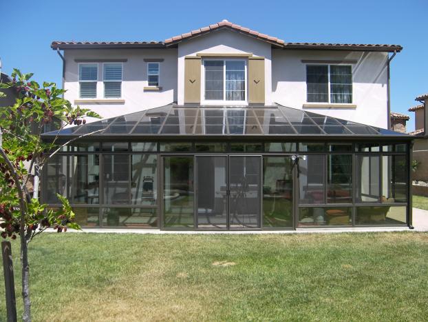 A beautiful exterior photo of a backyard addition spanning the width of the home.